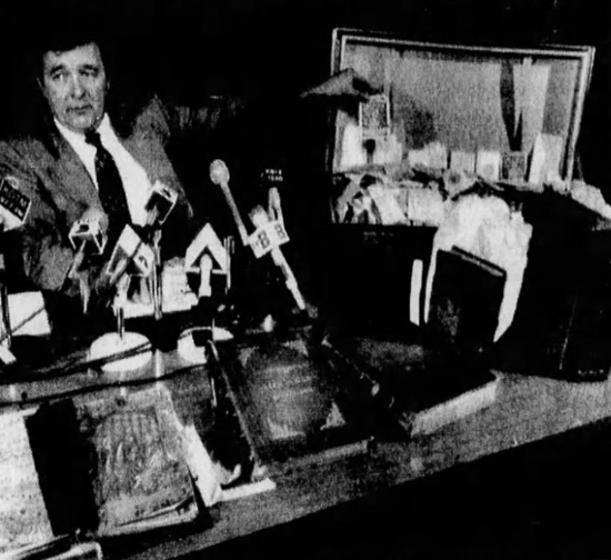 FBI agent W. Dennis Aiken displaying some of the stolen materials at a press conference.