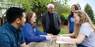 A Jesuit speaks with students at Creighton.