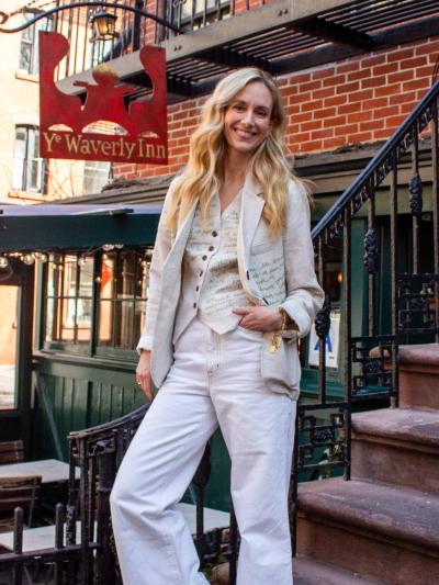 A woman smiles as she stands next to a set of steps