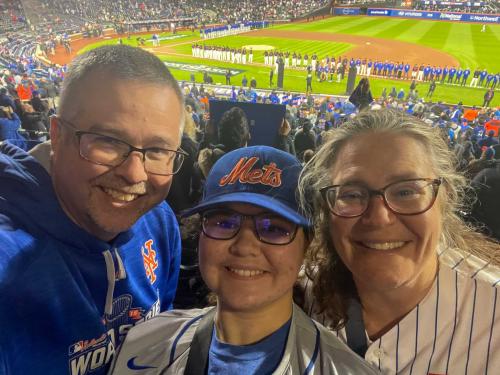 A family smiles together at a baseball game
