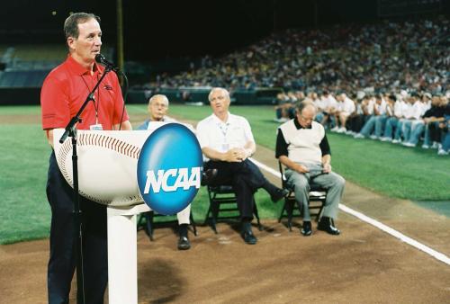 A man speaks to the crowd inside a baseball stadium