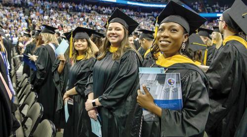 Vivian Amu stands among fellow graduates at a commencement ceremony.