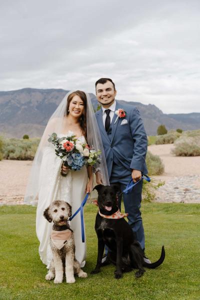 A married couple poses with two dogs
