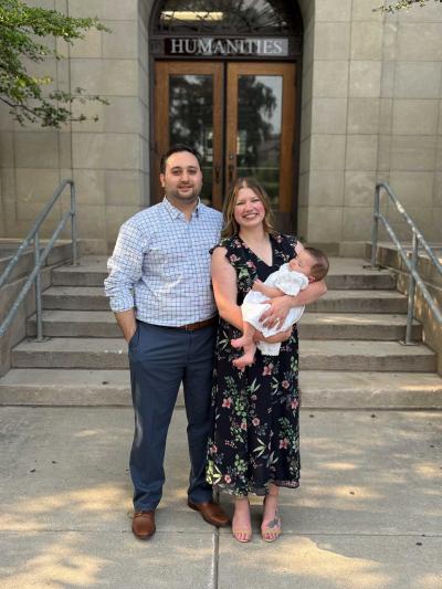 A couple poses with their baby
