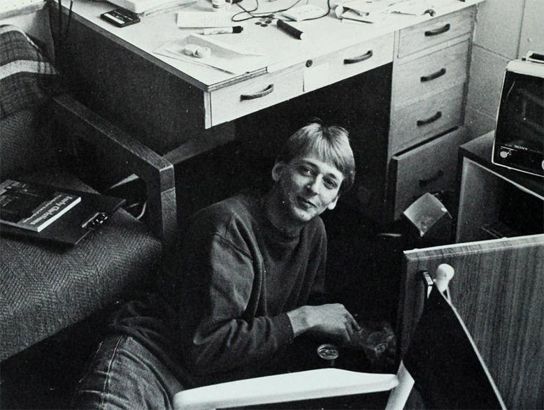 A student sits under his desk in Gallagher Hall.