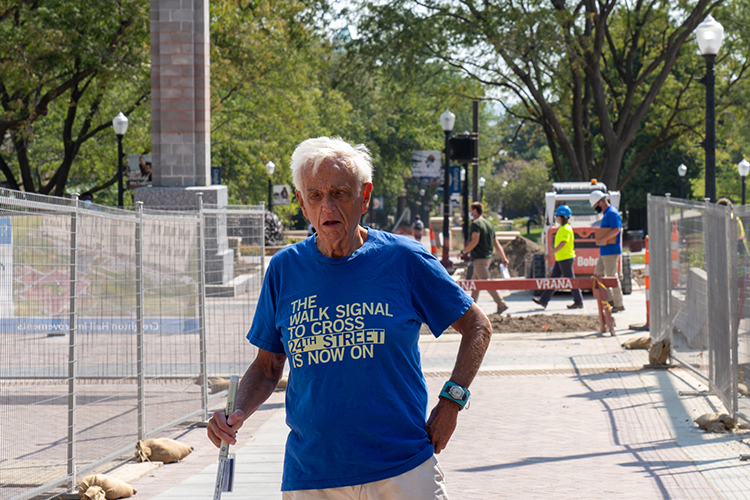 Fr. Larry Gillick, SJ, wearing walk signal shirt on Creighton campus