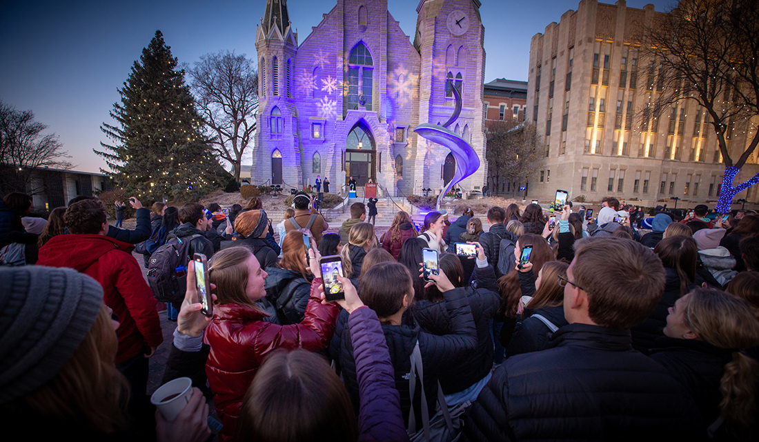 Students take part in Christmas at Creighton in front of St. John's Church.