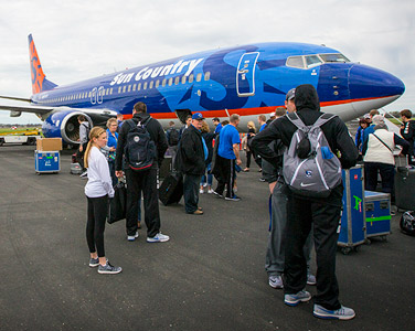 Creighton University athletics standing next to an airplane