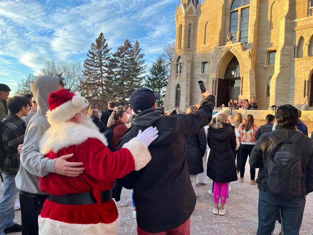 Santa Claus poses with students for a photo