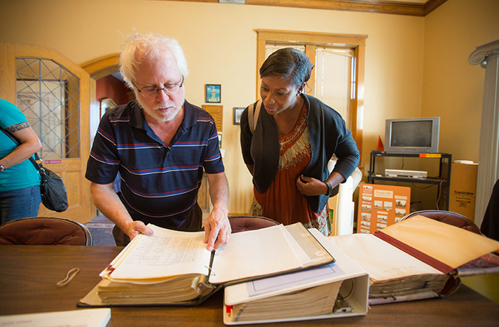 Professor and student look at book.