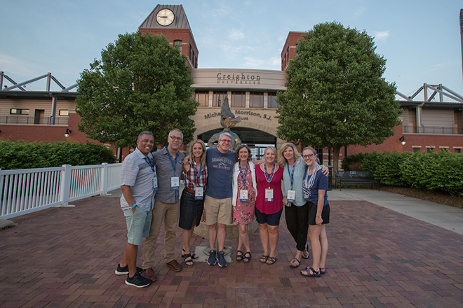 Creighton alumni standing before Morrison stadium