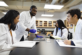 A faculty member leads students through a lesson in a classroom.