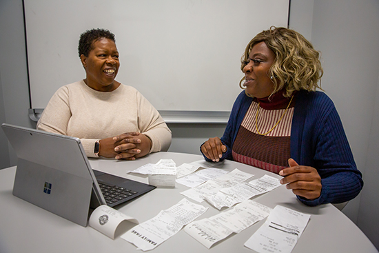 Carmen Bradley, left, a program supervisor with the Financial Success Program, meets with Brieann Clark as part of the Cura Project&rsquo;s financial success component.