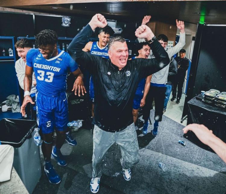 Creighton coach Greg McDermott celebrates a win with the team in the locker room.