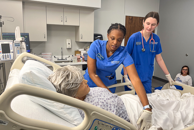Nursing students train on a manikin in the William and Ruth Scott Family Foundation Simulation Center.