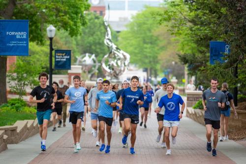 People jog down a campus sidewalk