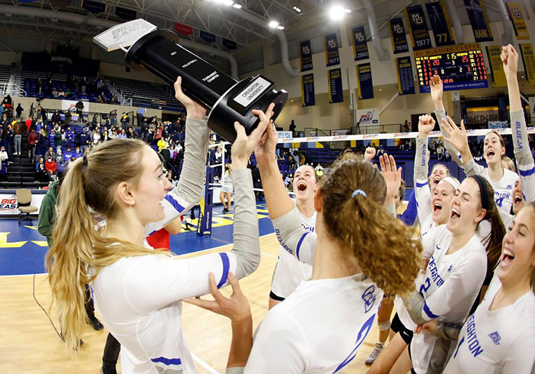 Women's volleyball team celebrates after winning the BIG EAST title.