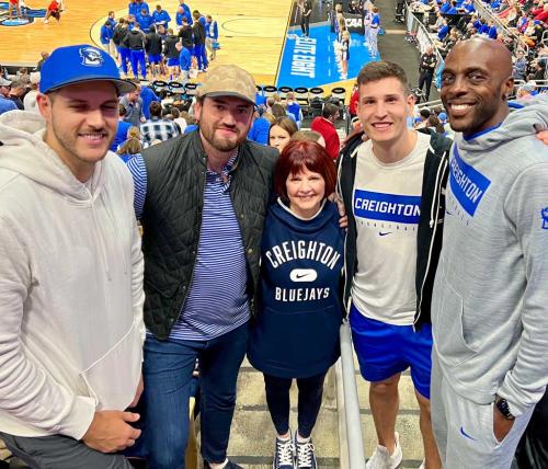 Patty Galas poses with four former Creighton men's basketball players