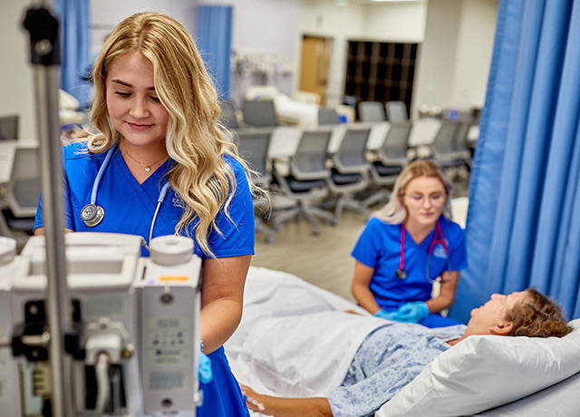 Two nurses treat a patient.