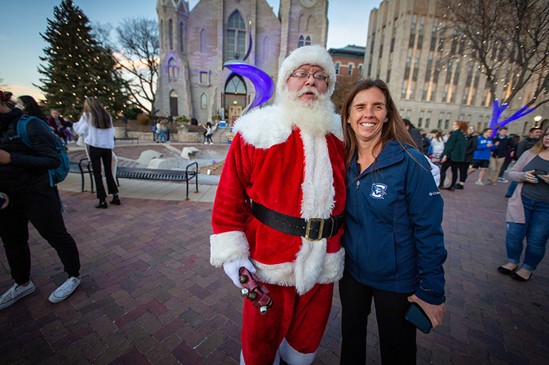 Staff pose with Santa at the Celebration of Light ceremony.