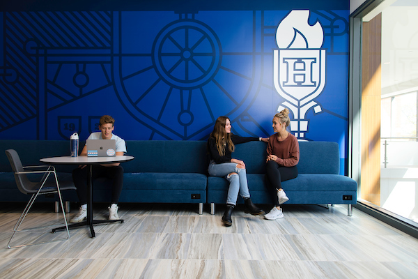 Heider College of Business still, students talking in front of logo.