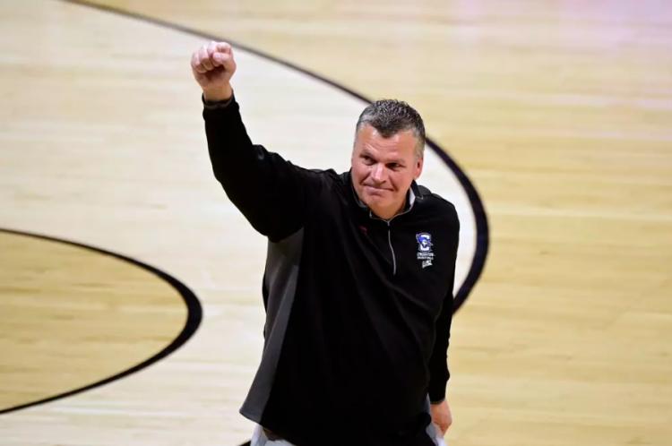 Greg McDermott raises his fist to the fans