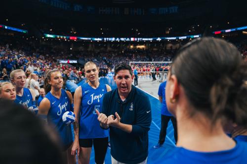 A volleyball coach talks to his team
