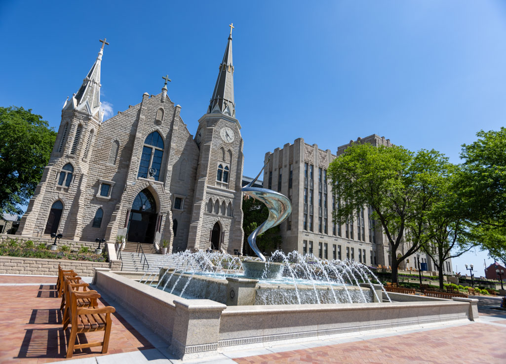 A photo of a fountain in front of a church