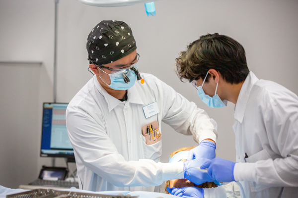 Student and resident operate on a patient at the After-hours Clinic.