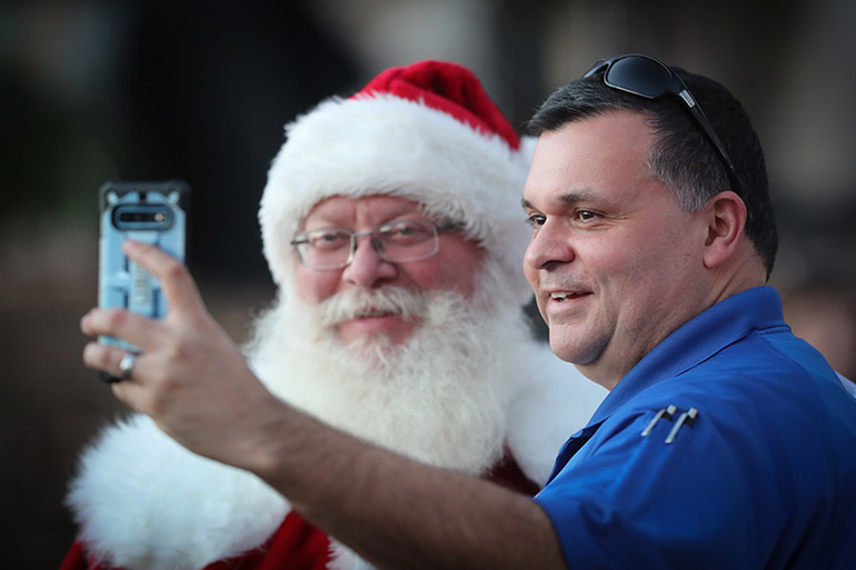 Staff pose with Santa at the Celebration of Light ceremony.