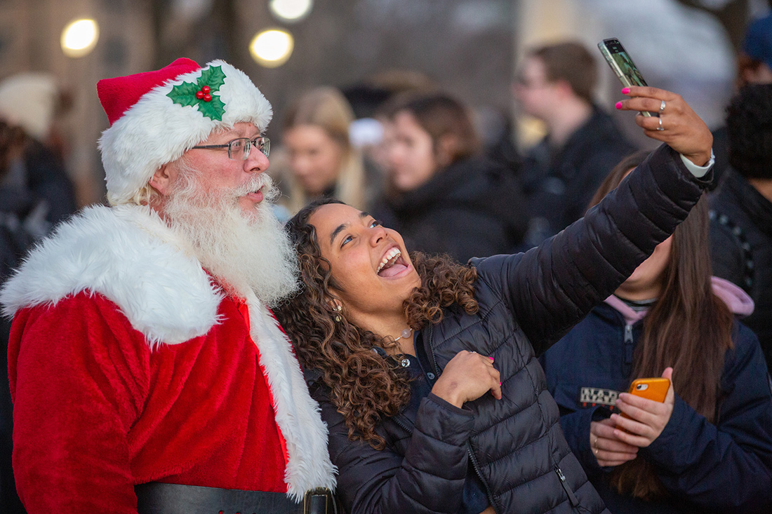 A student take a selfie with Santa during Christmas at Creighton.