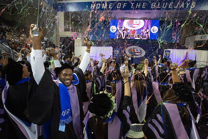 A student cheers at graduation.