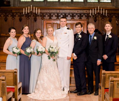 Emily and Mike Austerberry stand together with friends at their wedding.