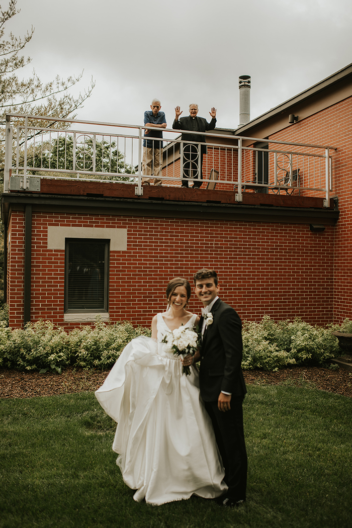 At their May 2020 wedding, Zoe and Jake social distance from Frs. Larry Gillick and Greg Carlson.