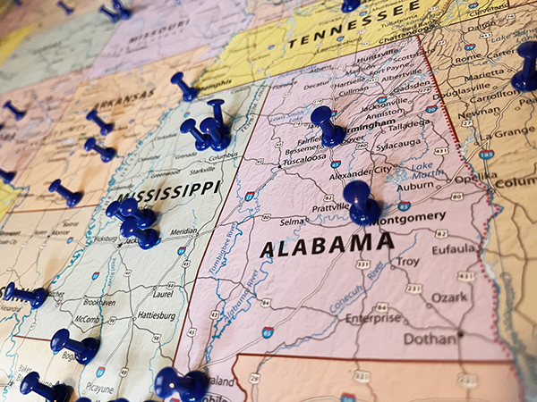 Alabama map with push pins in it.