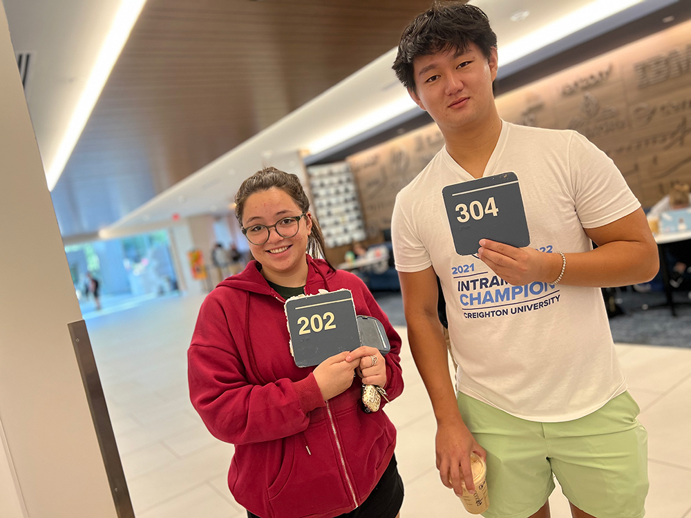 Students hold up room numbers at Gallagher Garage Sale