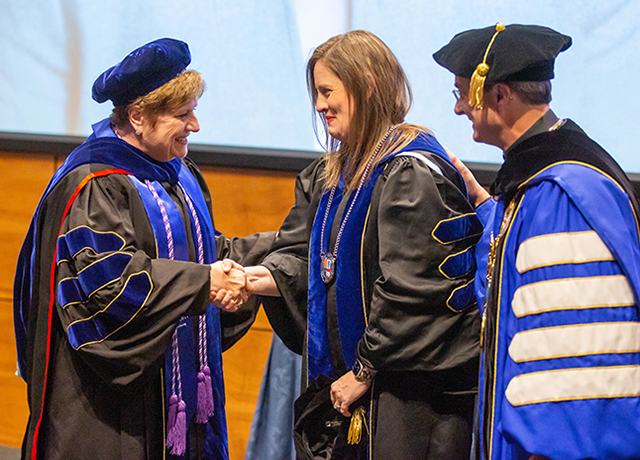 Dean Todero and Fr. Henrickson congratulate Meghan Potthoff.