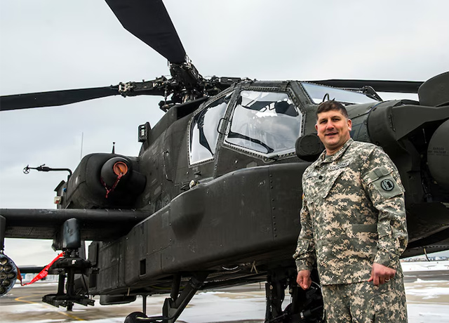 Matthew Badell in front of a helicopter.