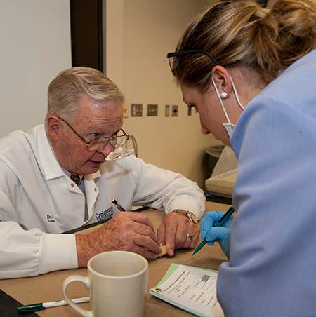 An image of Bill Carlisle speaking with a dentist.