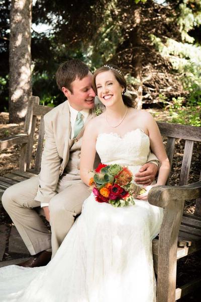 A married couple smiles on a bench