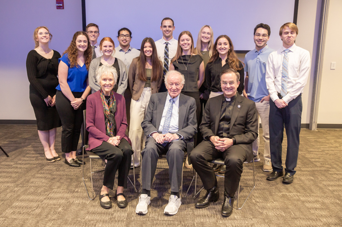 The 2023 cohort of Ferlic fellows pictures with the Ferlics and Creighton President Father Hendrickson. Stoffel pictured right behind Randolph Ferlic.