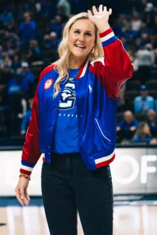 A woman smiles as she waves to an arena crowd