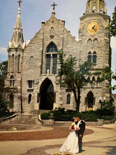 A couple embraces outside of St. John's church on their wedding day