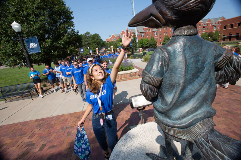 A student taps Billy Bluejay's beak during the Welcome Week Pathway event.