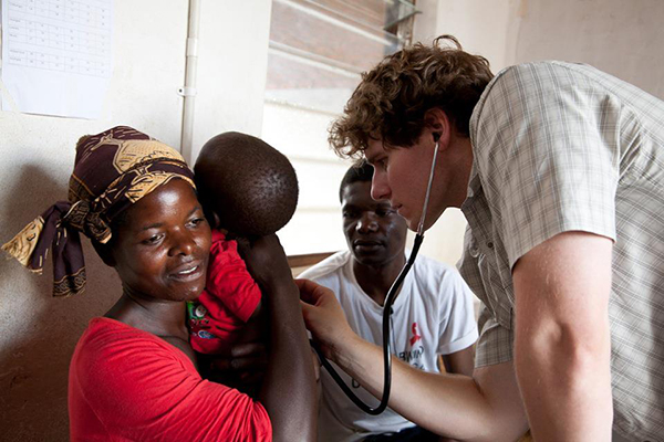 Jason Beste, right, cares for a patient in Africa. 