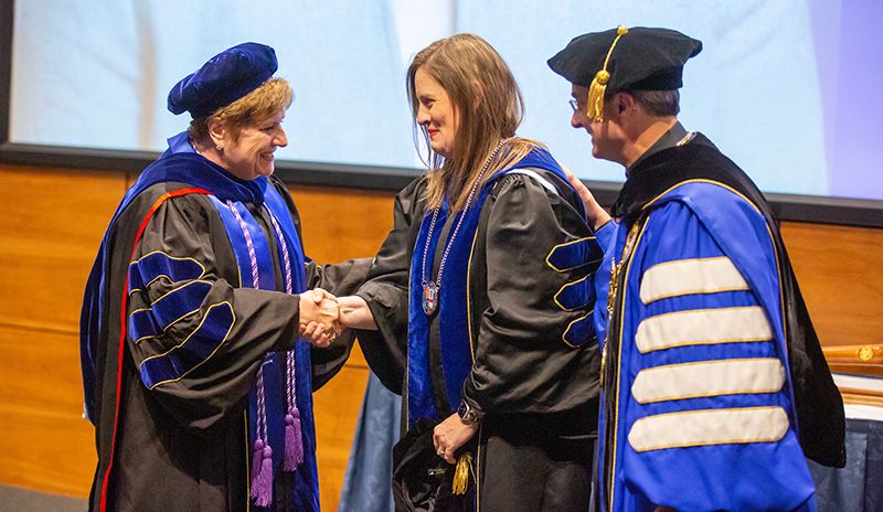 Dean Catherine Todero and Fr. Hendrickson congratulate Meghan Potthoff.