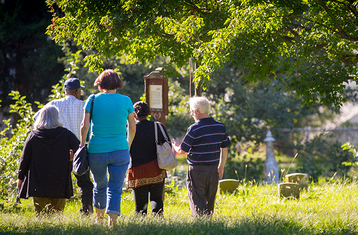 Professors and students walk in cemetery.