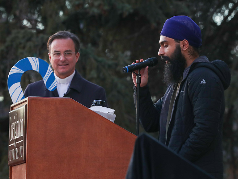 Fr. Hendrickson listens to a student speak at the Celebration of Light ceremony.