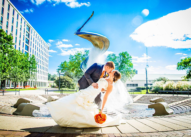 Carrie, OTD'12, BSHS'12, and Spencer Werth, BA'11, MS'14, JD'14, marriage photo in front of fountain