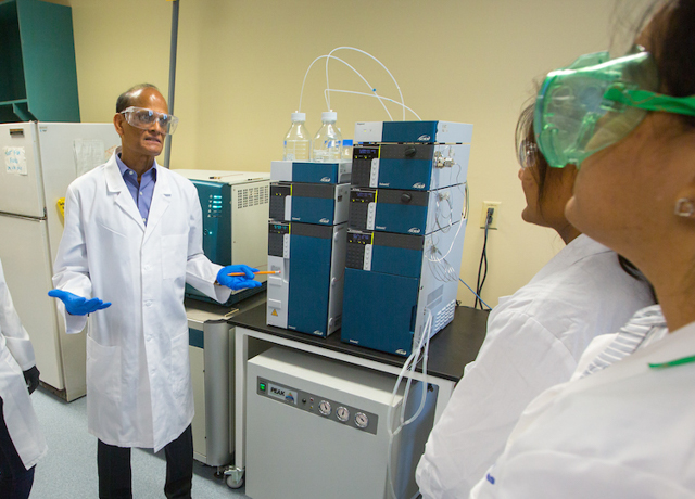 Alekha Dash speaks with students in his lab.